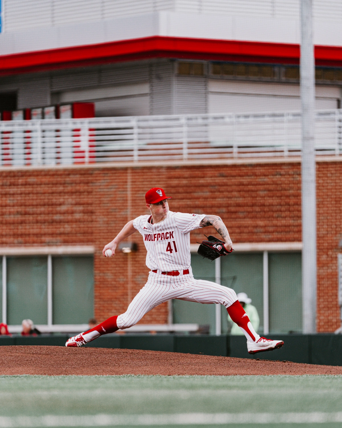 An NC State pitcher throwing in the indoor facility